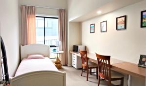a bedroom with a bed and a desk and a bed and chairs at A private room with lounge room in Unanderra