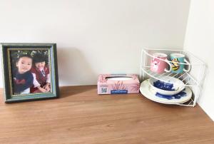 a picture of a child in a frame next to a plate at A private room with lounge room in Unanderra