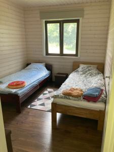 a bedroom with two beds and a window at Aru talu külalistemaja in Iilaste
