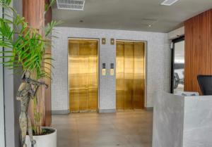 a lobby with gold doors and a potted plant at Torre Palmas Marcel in Ensanche Quisqueya +72 photos