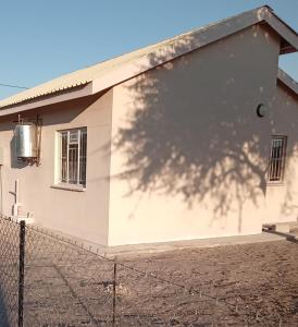 a building with a shadow of a tree on it at M's guest place Nata in Nata