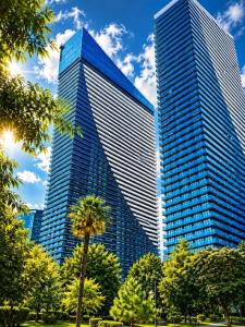 two tall skyscrapers in a city with a palm tree at Seaside Studio at Orbi City in Batumi