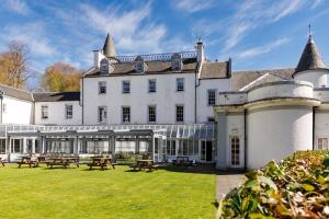 a large white building with picnic tables in the yard at Barony Castle Hotel in Peebles +105 photos
