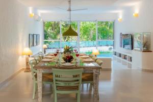 a dining room with a table and chairs at Aroha Palms Luxury Villas in Mandrem