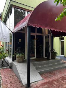 a building with a red awning outside of it at Hotel Cocó in Timişoara