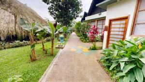 a walkway in front of a house with plants at Decameron Decalodge Ticuna in Leticia