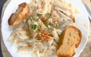 a plate of food with pasta and bread on a table at The Botanika Suites in New Town +26 photos