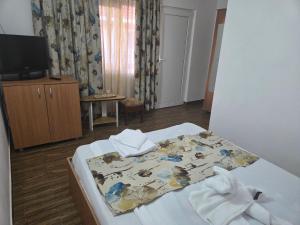 a bedroom with a bed with towels on it at La Camuflaj 2 Mai in 2 Mai