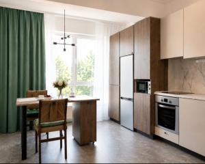 a kitchen with a table and a green curtain at Ap Blessedplace Rîșcani-New Bldg in Chişinău