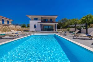 a swimming pool in front of a house at Villa ADRIA MOMENTS with private pool in Pinezici
