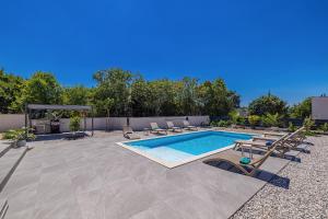 a swimming pool with chaise lounge chairs and a swimming pool at Villa ADRIA MOMENTS with private pool in Pinezici +42 photos