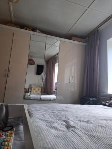 a bedroom with a large mirror and a bed at Cozy Stay Emir in Kazarman