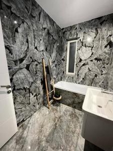 a bathroom with a stone wall with a tub and a sink at Adinna Residence in Giroc