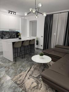 a kitchen and living room with a couch and a table at Adinna Residence in Giroc +5 photos