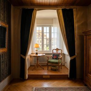 a room with a window with a chair and a table at Der Platengarten in Ansbach