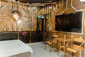 a room with a bed and chairs and a tv at Hotel Minh Cường Trà Vinh in Nguyệt Hòa