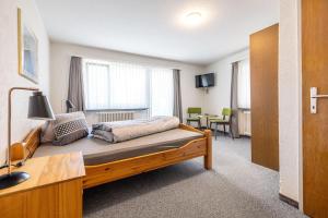a bedroom with a bed and a table in a room at Hotel Haus am Wald in Arosa
