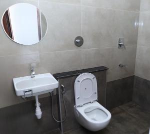 a bathroom with a toilet and a sink and a mirror at L2 Retreat in Kottakupam