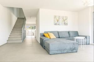 a living room with a blue couch and stairs at Stockhorn Apartment - Aare Jungfrau AG in Spiez