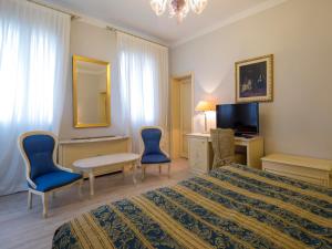 a hotel room with a bed and chairs and a television at Hotel Villa Braida in Mogliano Veneto