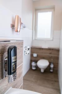 a bathroom with a toilet and a soap dispenser at Stadtperle Rostock in Rostock