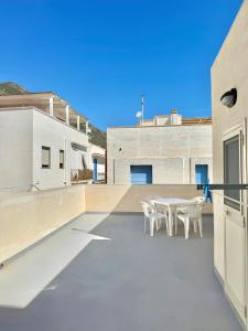 a patio with a table and chairs on a building at L'angolo blu in Marettimo