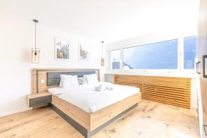 a bedroom with a large bed and a large window at Alpin Chic - Aare Jungfrau AG in Grindelwald +15 photos