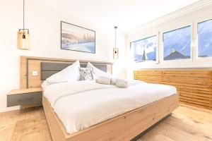 a bedroom with a large bed in a room with windows at Alpin Chic - Aare Jungfrau AG in Grindelwald