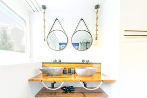 a bathroom with two mirrors above a wooden counter at Alpin Chic - Aare Jungfrau AG in Grindelwald