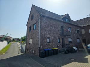 a brick building with trash cans in front of it at Ferienwohnung Nele in Heimbach
