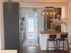 a kitchen with a counter and a kitchen island with stools at Hesketh Hideaway 1 in Marshside