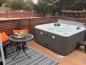 a hot tub on a deck with a table at Hesketh Hideaway 1 in Marshside