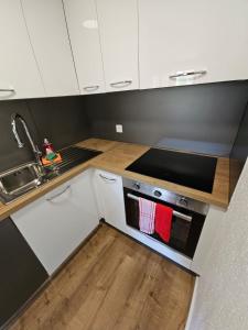 a kitchen with white cabinets and a sink and a stove at Peak Apartment - Aare Jungfrau AG in Grindelwald