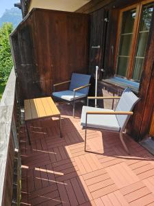 two chairs and a bench on a deck at Peak Apartment - Aare Jungfrau AG in Grindelwald