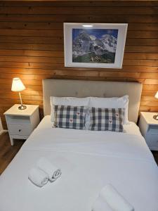 a bedroom with a white bed with two pillows at Peak Apartment - Aare Jungfrau AG in Grindelwald +15 photos