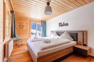 a bedroom with a large bed with a wooden ceiling at Apartment Chalet Condor - Aare Jungfrau AG in Grindelwald