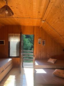 a bedroom with two beds in a wooden house at Weekendica in Kopaonik