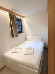 a bed in a room with two towels on it at Hotel Le Chamonix in Chamonix
