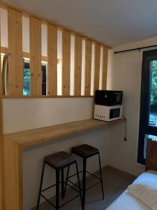 a room with a counter with two stools and a microwave at Hotel Le Chamonix in Chamonix