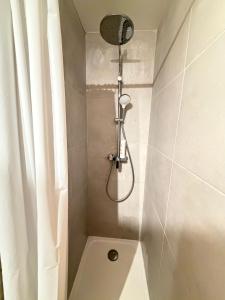 a shower with a shower head in a bathroom at Hotel Le Chamonix in Chamonix