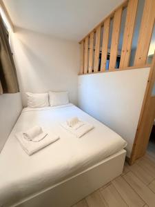 a bed in a small room with two towels at Hotel Le Chamonix in Chamonix +25 photos