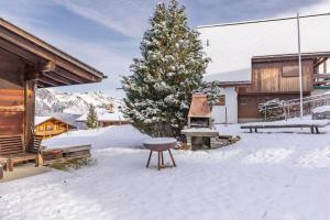 ein Picknicktisch im Schnee neben einer Hütte in der Unterkunft Sara in Axalp