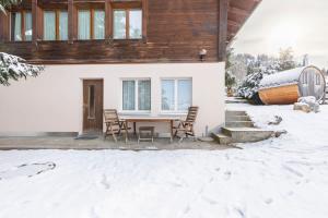 a house with a table and chairs in the snow at Schwabhorn in Axalp +23 photos