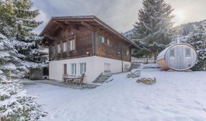 a house in the snow with a barrel at Schwabhorn in Axalp