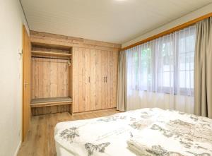 a bedroom with a bed and a large window at Kehr Apartment - Aare Jungfrau AG in Grindelwald