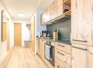a kitchen with wooden cabinets and a counter top at Kehr Apartment - Aare Jungfrau AG in Grindelwald