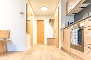 a kitchen with wooden cabinets and a wooden floor at Kehr Apartment - Aare Jungfrau AG in Grindelwald +10 photos