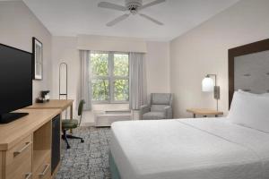 a hotel room with a bed and a desk and a television at Homewood Suites by Hilton Raleigh/Cary in Cary +40 photos