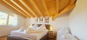 a bedroom with two beds and a wooden ceiling at Jungfrau Penthouse - Aare Jungfrau AG in Wilderswil