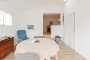 a living room with a table and chairs and a room at Libellule - Proche plage - Terrasse in Pornichet